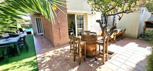 a patio with a table and a barrel at Casa con piscina en costa Barcelona in Sant Vicenç de Montalt