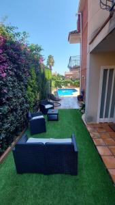 a backyard with a lawn with couches and a pool at Casa con piscina en costa Barcelona in Sant Vicenç de Montalt