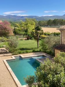 a swimming pool in the yard of a house at ferme st pierre 2 suites avec repas, piscine, clim, cheminée ou baignoire spa in Chabeuil