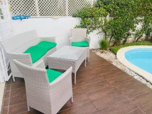 Un patio con mesa y sillas junto a una piscina. en villa azur, en Dar Bouazza