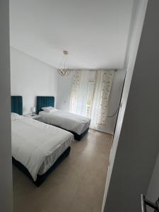 Un dormitorio con dos camas y una ventana. en villa azur, en Dar Bouazza