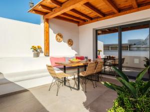 a patio with a wooden table and chairs at LevandaMykonos in Mikonos