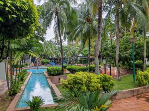 a swimming pool in a resort with palm trees at Urban Oasis Apartment 6 in Melaka
