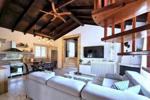 un soggiorno con un divano bianco e una cucina di Villa Claire Corfu a Gastouri