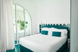 a bedroom with a large bed with a mirror at CALEA Boutique Hotel in Bacoli