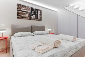 a white bedroom with a large bed with towels on it at San Siro Ippodromo - Rho Fiera Elegant Two-story Loft in Milan