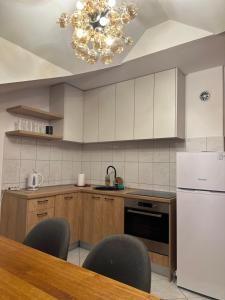 a kitchen with a table and chairs and a chandelier at Grand apartman in Banja Luka