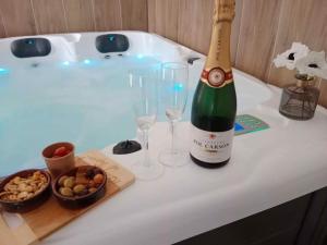 a bottle of champagne and two glasses on a bath tub at Ô'BEL AIR in Azur