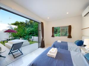 1 dormitorio con 2 camas y patio en Chura Kouri, en Nakijin