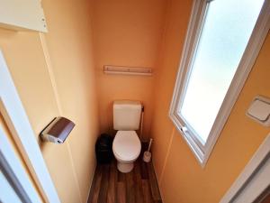 a small bathroom with a toilet and a window at Voll klimatisiertes Mobile Home mit Wi-Fi am Europa-Park in Boofzheim +9 photos