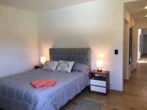 a bedroom with a bed and two lamps on tables at Casa en Barrio Costa Esmeralda Pinamar in Costa Esmeralda +9 photos