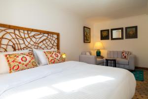 Un dormitorio con una gran cama blanca y sillas. en Kasbah House, en Tánger