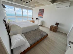 a bedroom with a large bed and a large window at Exclusivo y con vista al mar 602 in Cayo Santander +13 photos