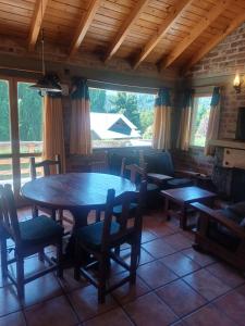 a dining room with a table and chairs in a house at Cabaña Las Aljabas 1 in San Martín de los Andes