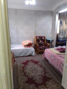 ein kleines Zimmer mit 2 Betten und einem Stuhl in der Unterkunft ادفو 35سرير ثلاثي in Alexandria
