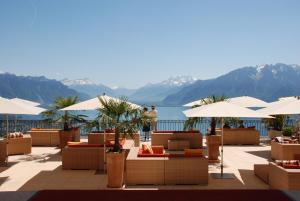 un complexe avec des tables, des parasols et un lac dans l'établissement Le Mirador Resort & Spa, à Vevey