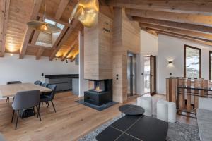 a living room with a table and a fireplace at Chalet Grand Lac in Chandon