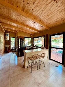 a kitchen with a counter and two chairs in a room at Casa Bambú - Brisas del Lago in Puerto Bossetti