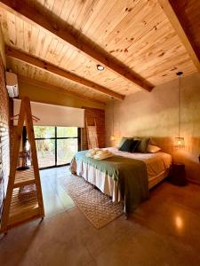 a bedroom with a bed in a room with wooden ceilings at Casa Bambú - Brisas del Lago in Puerto Bossetti +20 photos