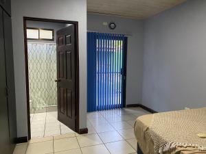 a room with a bed and a door with a window at Spacious Beach House with Private Pool in Playa Hermosa