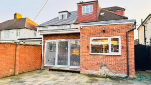 a red brick house with a large window at Isleworth House London by Smart Corporate Stays in London