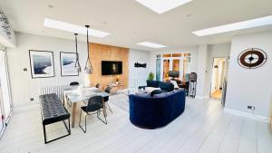 a living room with a blue couch and a table at Isleworth House London by Smart Corporate Stays in London
