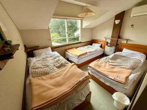 Ένα ή περισσότερα κρεβάτια σε δωμάτιο στο ペンションハウディー
