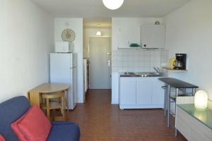 a kitchen with a couch and a table and a refrigerator at Studio CAP D'AGDE CT121-019 in Cap d'Agde
