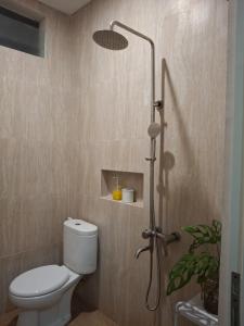 a bathroom with a shower with a toilet and a shower head at Anagata House-villa 3BR at C8 Grand Kusuma Hill in Batu +24 photos