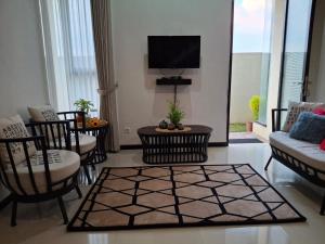 a living room with a couch and chairs and a tv at Anagata House-villa 3BR at C8 Grand Kusuma Hill in Batu