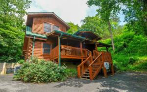 a log cabin with a staircase leading up to a deck at Bear Retreat in Pigeon Forge