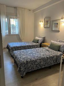 贝尼多姆Casa en la naturaleza en Benidorm的有两张床和一扇窗户的酒店房间