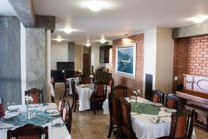 a dining room with tables and chairs and a piano at Dakota Lodge in Alberton