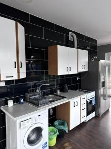 a kitchen with a sink and a washing machine at Domki pod Kurzą Górą in Kurzętnik +20 photos