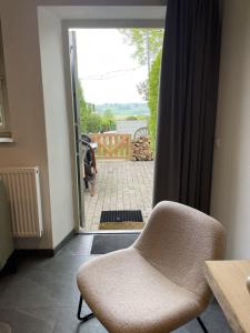 a room with a chair in front of a door at Sfeervolle 4 persoons cottage vlakbij Valkenburg in Voerendaal