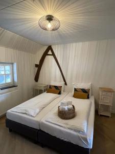 une chambre avec un grand lit avec un panier dessus dans l'établissement Gezellige cottage bij Valkenburg, à Voerendaal