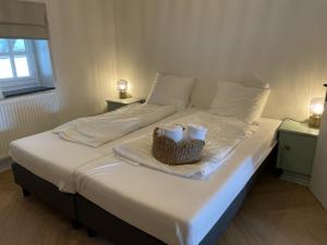 a bed with two towels and a basket on it at Gezellige cottage bij Valkenburg in Voerendaal