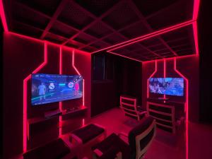 Camera con illuminazione rossa, sedie e TV di Elysian Airport Hotel a Arnavutköy