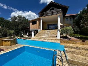a house with a swimming pool in front of a house at Villa Somlyó in Fót