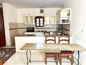 a kitchen with a wooden table and chairs at Sunset Haven in Luxor +18 photos