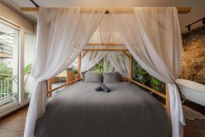 a bedroom with a bed with a canopy and a tub at Bong House close to train street at the Hanoi old quarter in Hanoi