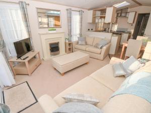 un salon avec un canapé et une cheminée dans l'établissement Beach Bliss Retreat, à Chichester