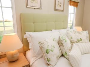 - un lit avec des oreillers blancs et une lampe sur une table dans l'établissement Beach Bliss Retreat, à Chichester