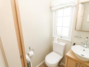 une salle de bain avec toilettes, lavabo et fenêtre dans l'établissement Beach Bliss Retreat, à Chichester 13 autres photos