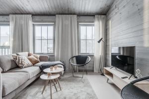 a living room with a couch and a tv at Bastuvallen - Ramundberget in Bruksvallarna