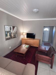 ein Wohnzimmer mit Sofa und Tisch in der Unterkunft Searle Cottage in George