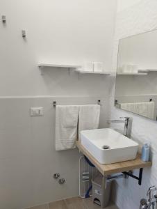 une salle de bain avec un lavabo blanc et un miroir dans l'établissement Vento di Mare, à Trapani
