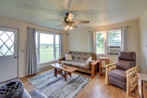 Una sala de estar con un sofá y una silla y ventanas. en Pet-Friendly and Peaceful Northern Michigan Gem, en Newberry