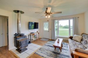 Una sala de estar con un sofá y una estufa. en Pet-Friendly and Peaceful Northern Michigan Gem, en Newberry