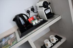 a shelf with a coffee maker and cups on it at Vikings Accommodation in York +70 photos
